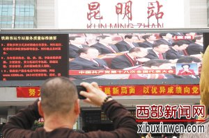在昆明火车站一位市民用手机记录十八大开幕直播 王中杰