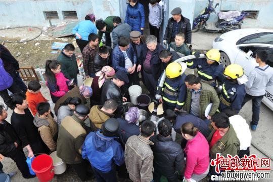 图为新疆阿勒泰市消防人员正在为居民送水。 仝慧 摄