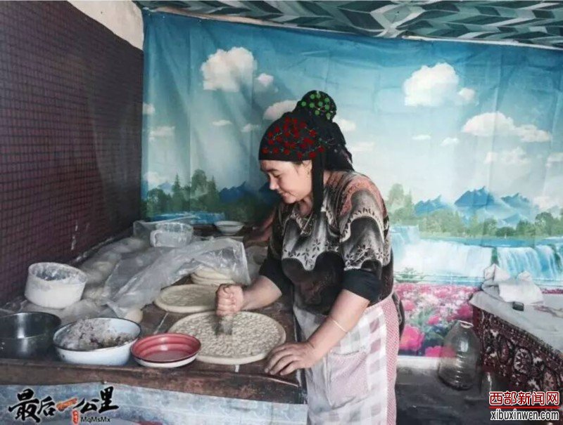 焦黄的馕熟了,祖丽菲亚·阿不力孜的大儿子赛都拉·阿不力克木用两根铁钩把馕一个个地钩了出来,看着都让人眼馋。